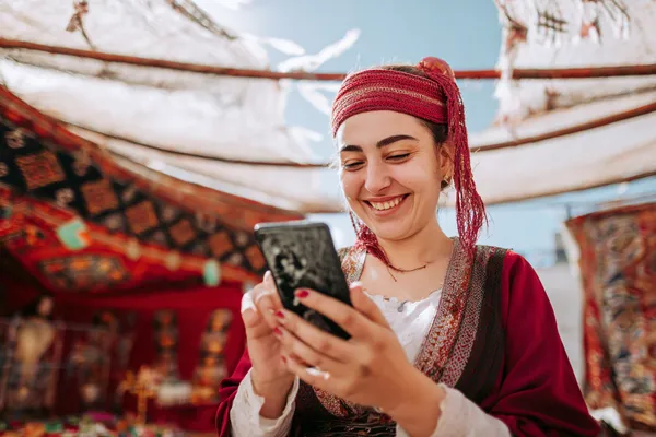 A player using their smartphone during a festive local event, representing KOKOZINO’s fully mobile-friendly casino.